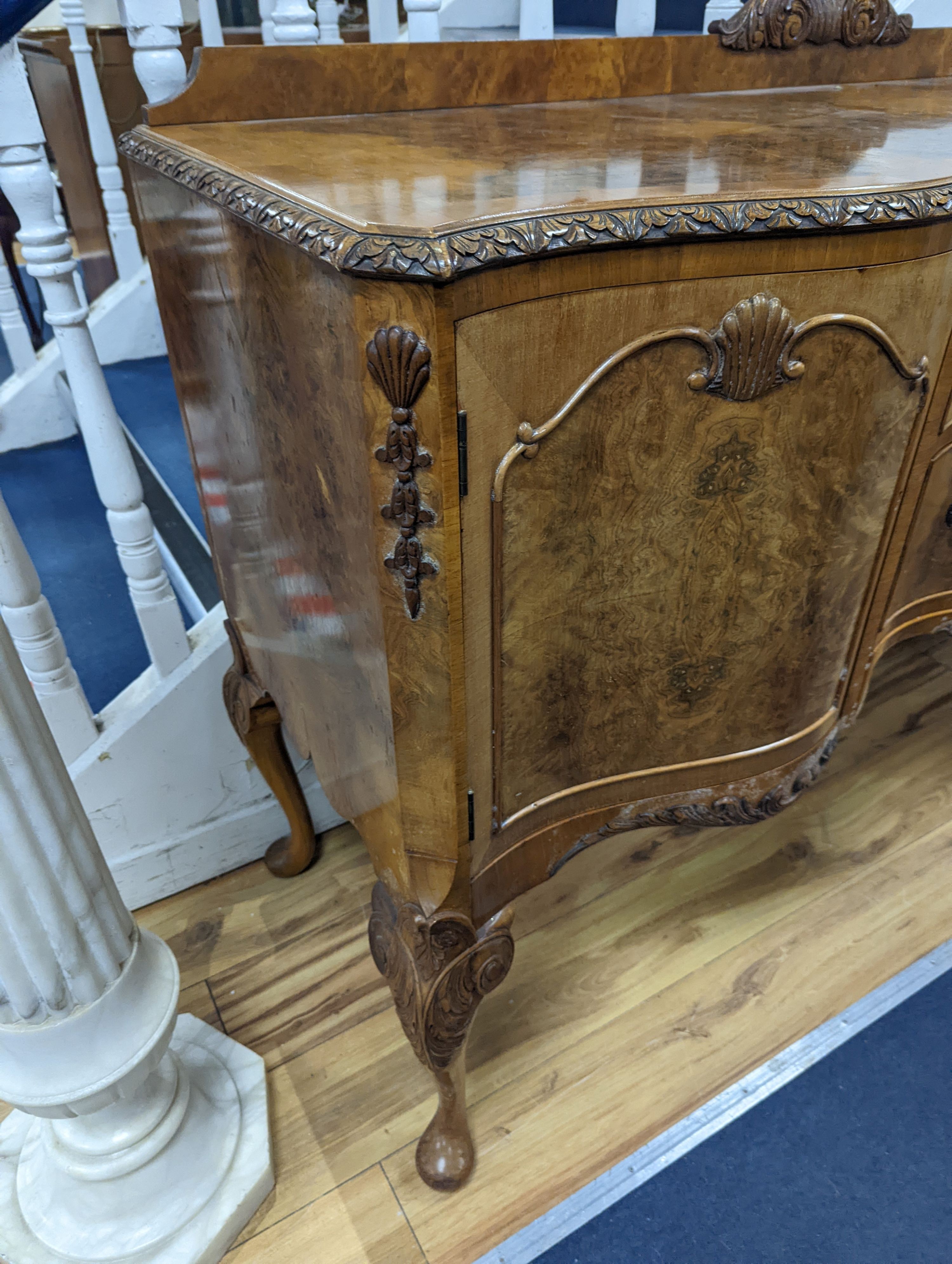 A Queen Anne revival burr walnut dining suite, comprising serpentine sideboard, length 168cm, depth 56cm, height 98cm, extending dining table, 210cm extended, one spare leaf, width 90cm, height 75cm and eight chairs, two